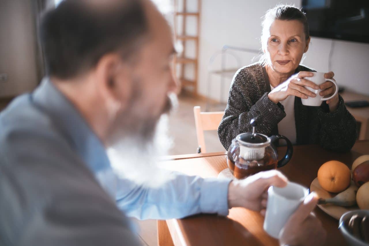 Woman and her husband enjoying coffee at the breakfast table.