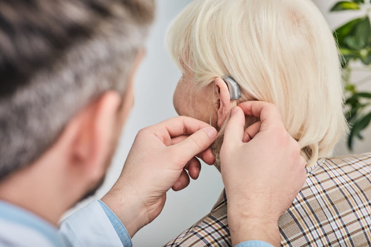 Senior woman getting fitted with a hearing aid.