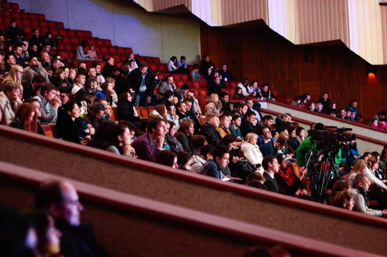 Group of people watching a performance at a concert hall.