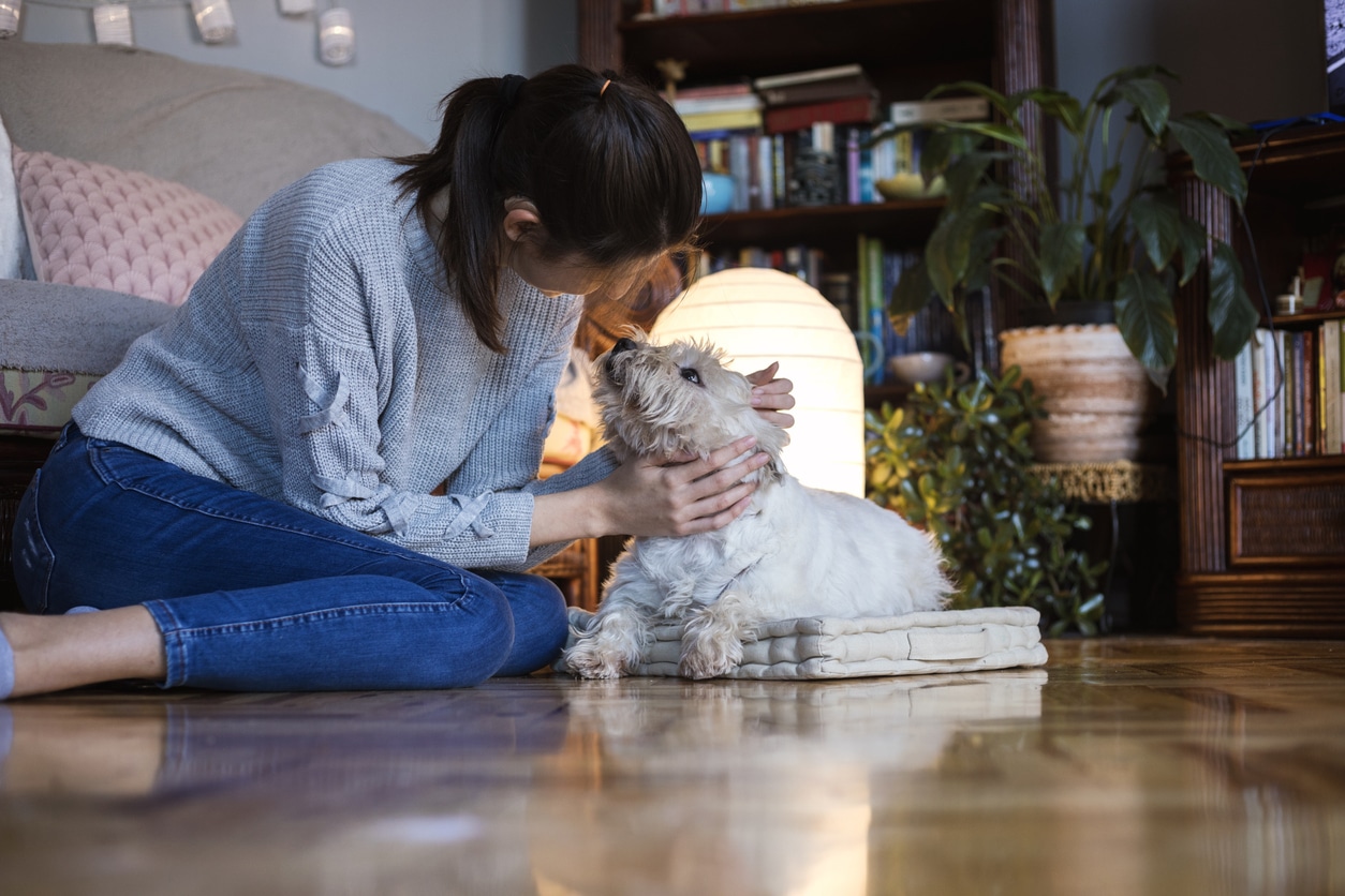 Woman with hearing aid pets dog