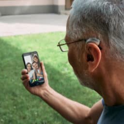 Man uses hearing aid on the phone