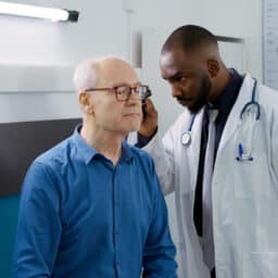 Audiologist examining a patient's ear before a hearing test.