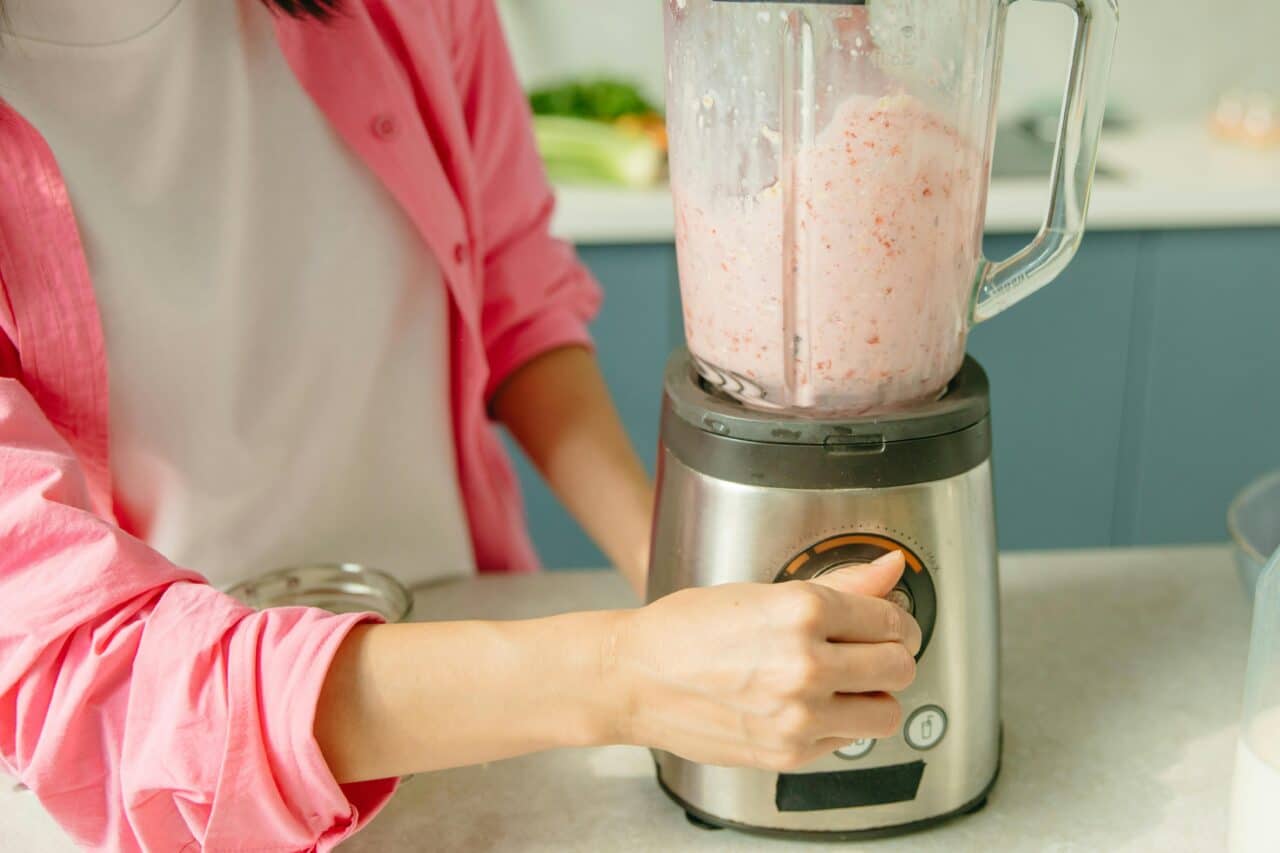 A person turns their loud blender on to make a smoothie.