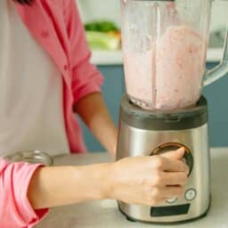 A person turns their loud blender on to make a smoothie.