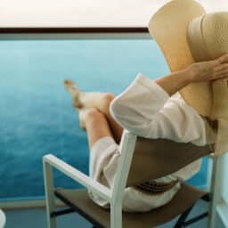 Stylish woman enjoying a cocktail on a luxurious cruise vacation.